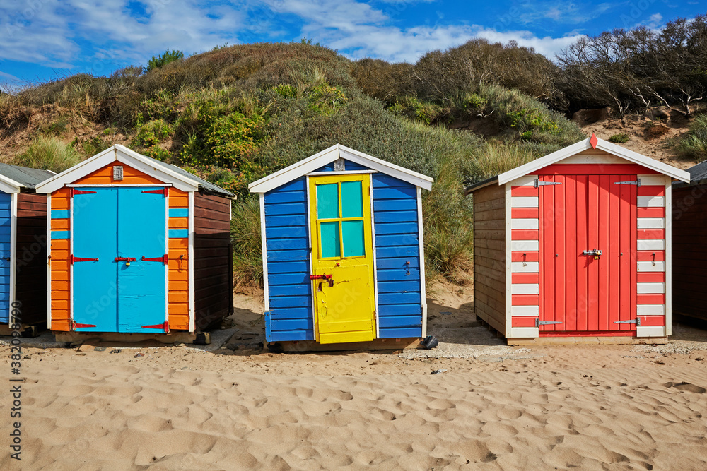 Rows of multi-coloured beach huts along Saunton Sands in North Devon, UK Rows of multi-coloured beach huts along Saunton Sands in North Devon, UK