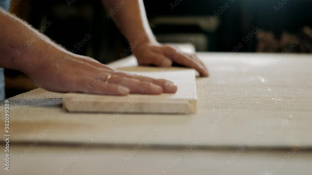Carpenter checks the quality sanding wooden board. Carpentry, craftsmanship, Handicrafts, woodwork and people concept. Carpenter checks the quality sanding wooden board. Carpentry, craftsmanship, Handicrafts, woodwork and people concept.