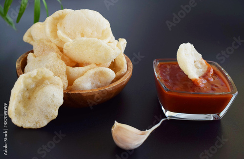 Fresh Krupuk on dark background.Prawn Crackers or Shrimp Chips with ketchup and garlic photo