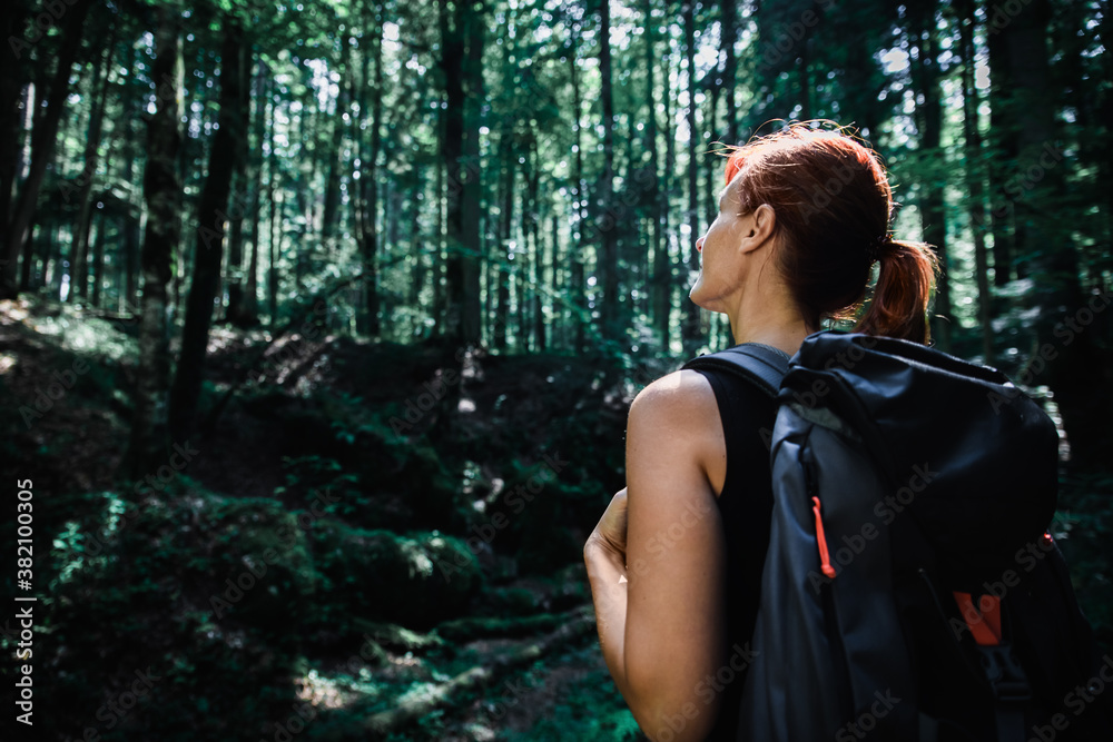 Female hiker with backpack enjoying hiking in forest. Female hiker with backpack enjoying hiking in forest.