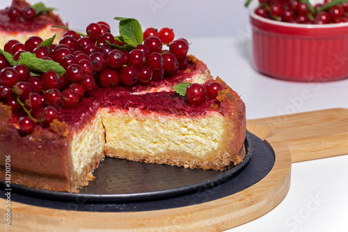 Cheesecake with red currant and mint on wooden board. Top view.