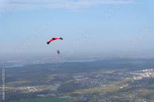 Skydiving. A parachute is in the sky.