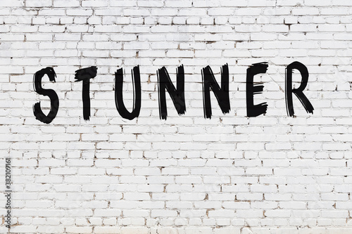 Inscription stunner painted on white brick wall