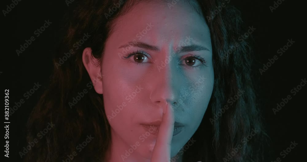 An young beautiful woman is shushing, mute point or stop with his gestures. Ssh concept, calm and relax. An young beautiful woman is shushing, mute point or stop with his gestures. Ssh concept, calm and relax.