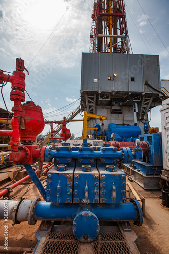 Oil deposit in desert. Mud pump on drilling rig and sky background.