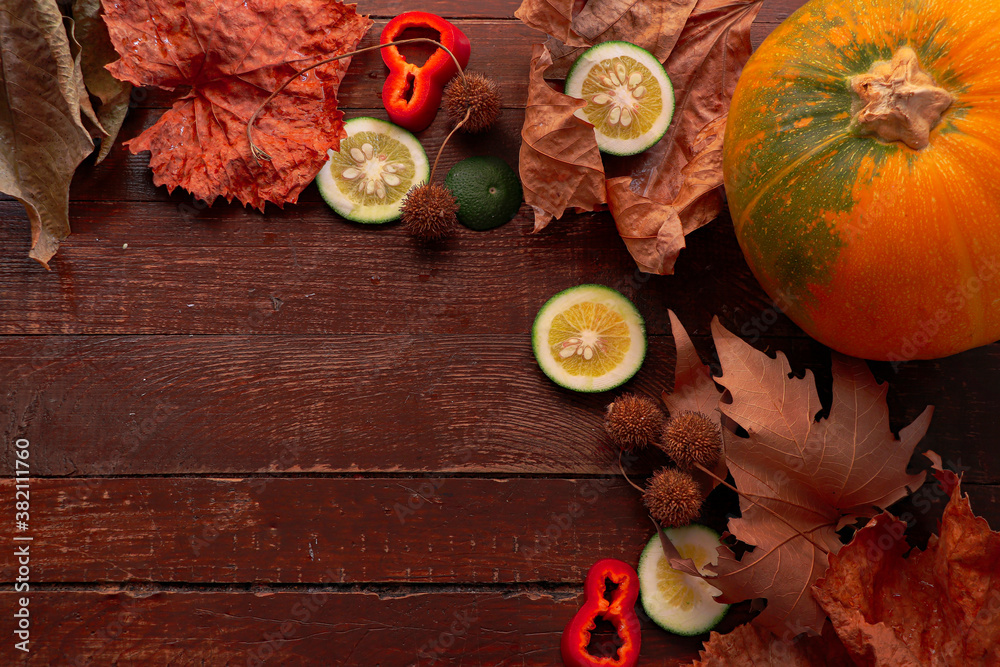 Autumn composition; Apple, pumpkin and fallen leaves on wooden background. Halloween, Thanksgiving or seasonal autumn. Design fitting. Horizontal