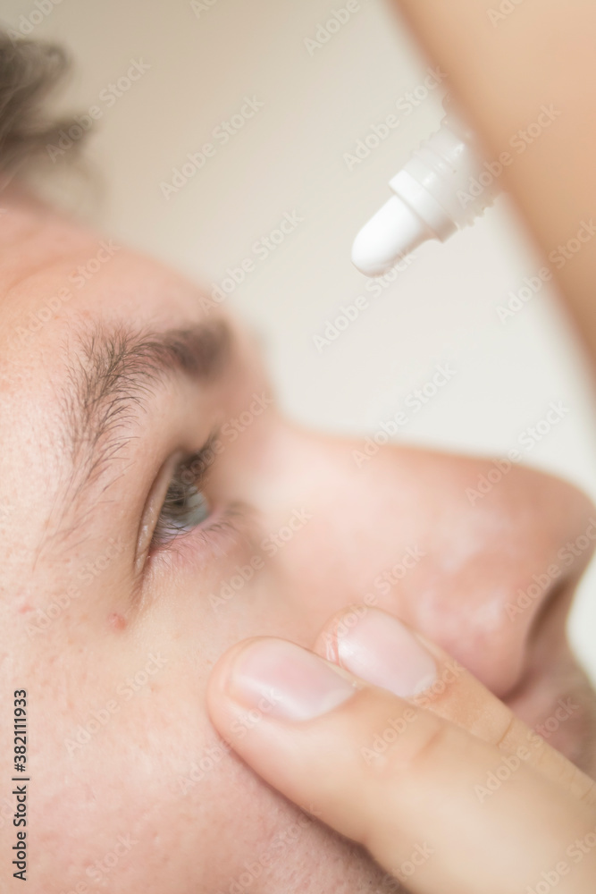 Naklejka premium Guy drips his eyes with drops