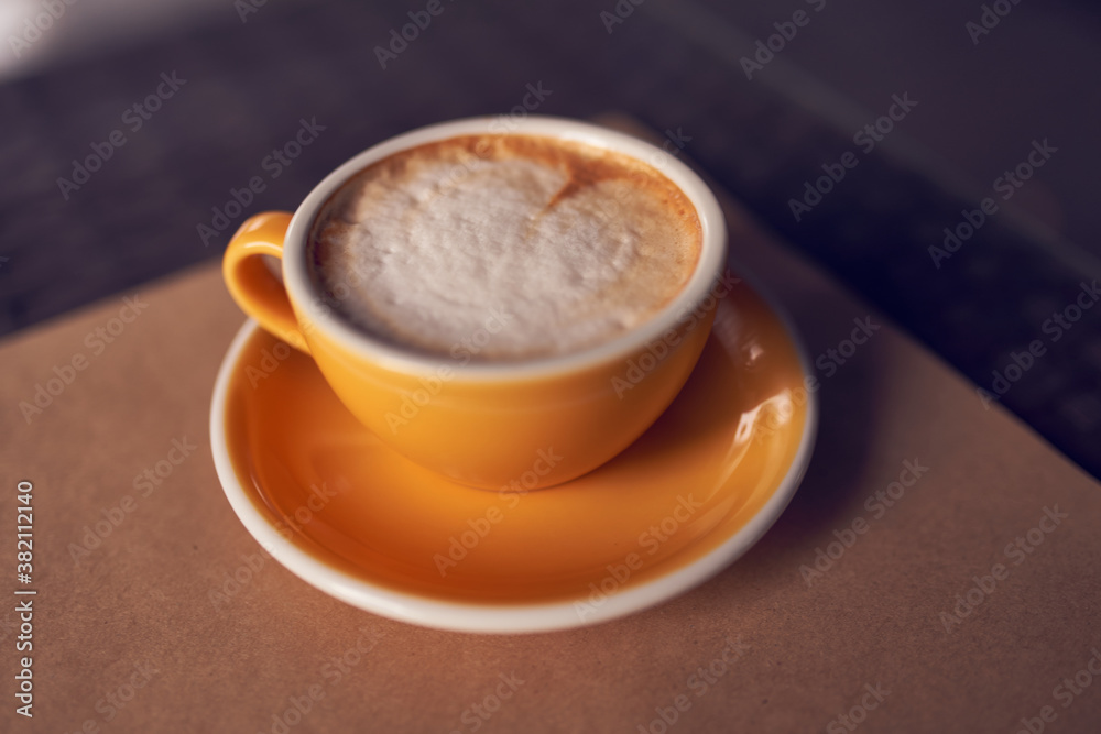 Cappuccino in the beautiful yellow ceramic cup. Beautiful foam and ceramic cup