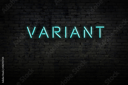 Neon sign. Word variant against brick wall. Night view photo