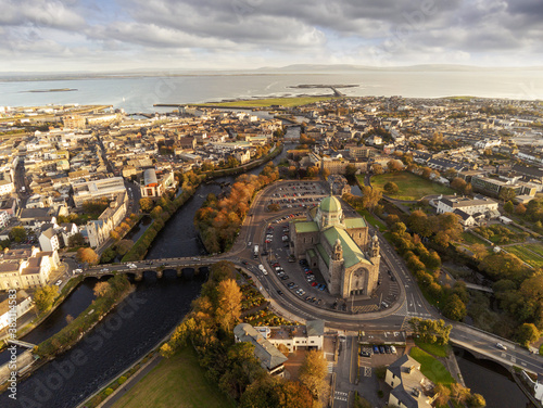 Galway Cathedral building at sunset. Aerial drone view, Warm light, Galway town, Ireland, Popular landmark. Cloudy sky.