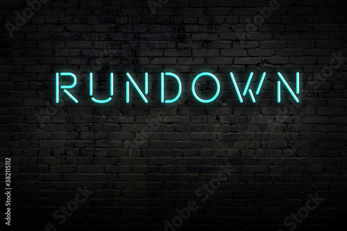 Night view of neon sign on brick wall with inscription rundown