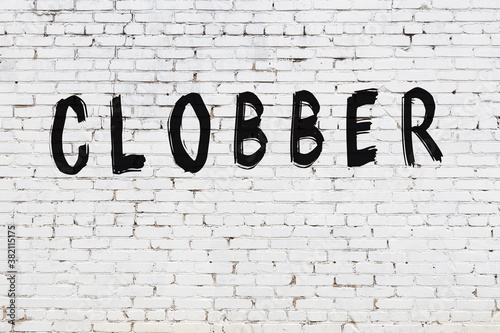 Inscription clobber painted on white brick wall