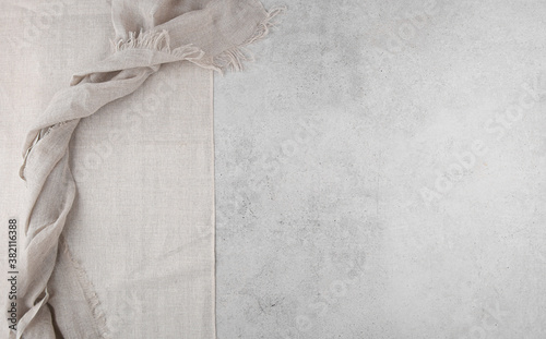 Pure washed linen cloth and tablecloth on light grunge stone background. Natural washed linen fabric on stone tile surface with copy space photo
