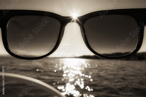 Sonnenbrille und Sonnenstern in Sepiatönen auf dem See