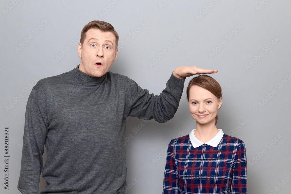 Tall man is showing height of short woman, people of different heights  Photos | Adobe Stock