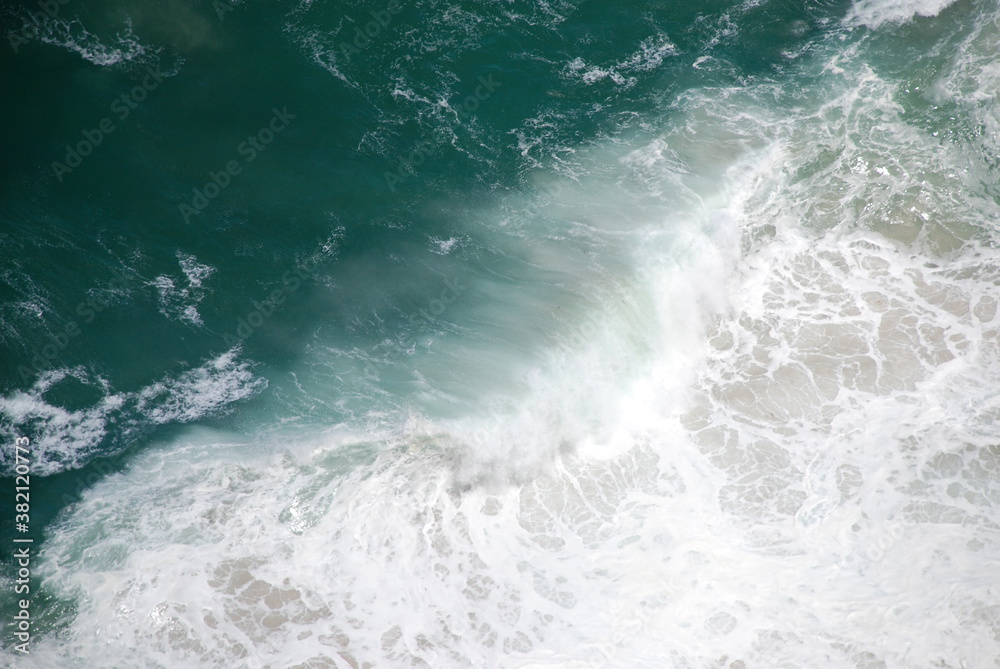 Abstract wild coast line with sea foam and crashing waves shot from above. Birdseye/aerial view. Shot in South Africa.