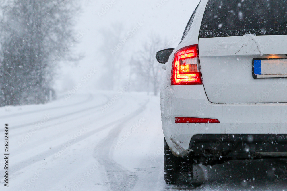 Car on country Winter, snow, poor visibility on the road. Car during a snowfall on the road with the headlights