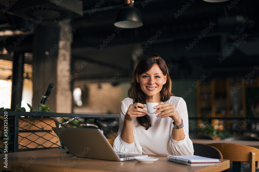 Sitting alone, working, enjoying in her coffee. Sitting alone, working, enjoying in her coffee.