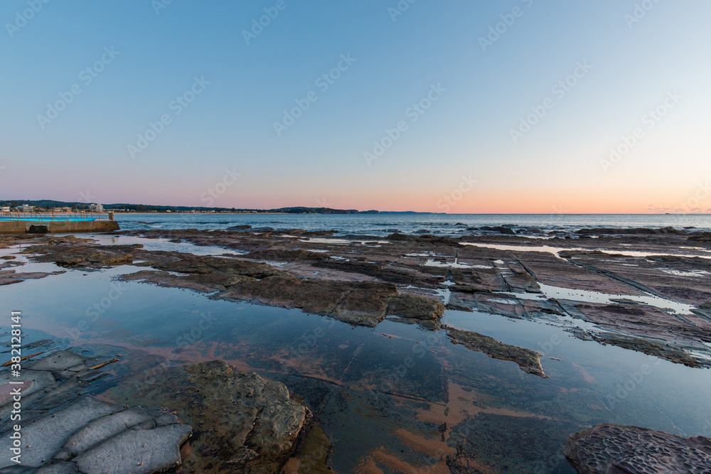 Fototapeta premium Rocky seascape with clear sunrise sky.