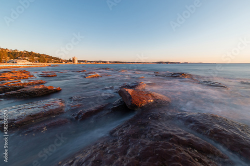 Water flowing between rocks at Collaroy Beach in the morning.