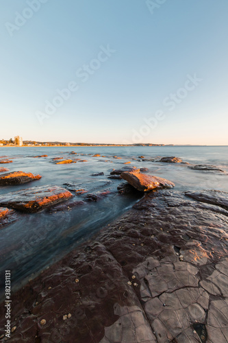 Sea water flowing between rocks on the coastline.