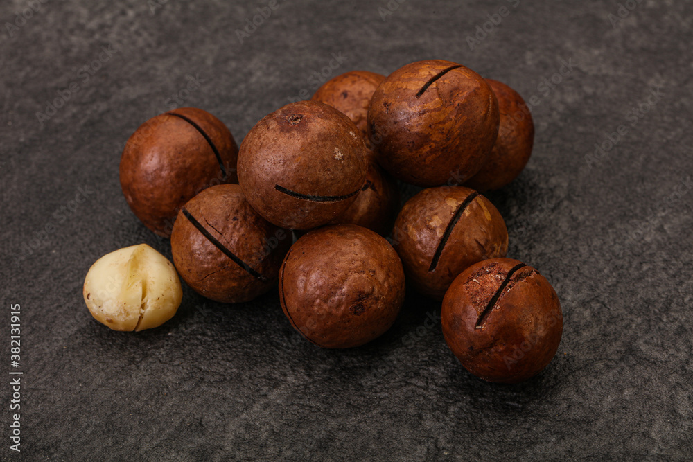 Obraz premium Brown macadamia nut heap over background