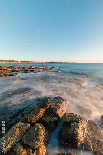 Water flowing around the rocky coastline.