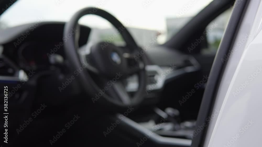 The front door of a modern car gets open and reveals the blurry black interior with a steering wheel, then the door gets closed The front door of a modern car gets open and reveals the blurry black interior with a steering wheel, then the door gets closed