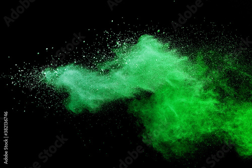 Green powder explosion on black background. © piyaphong
