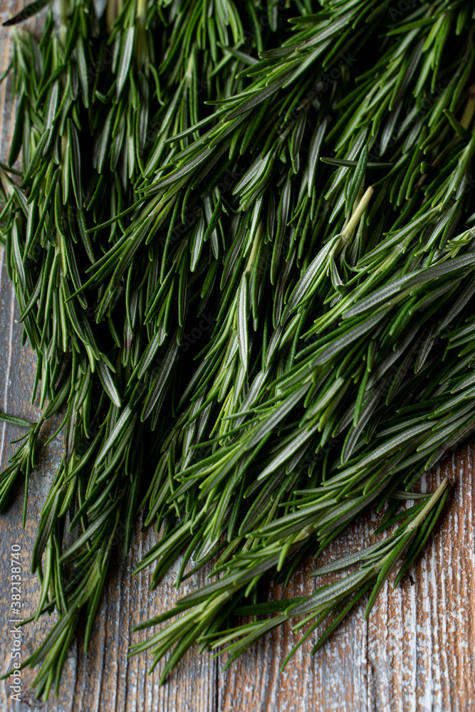 Rosemary branches laying on light wooden background Rosemary branches laying on light wooden background