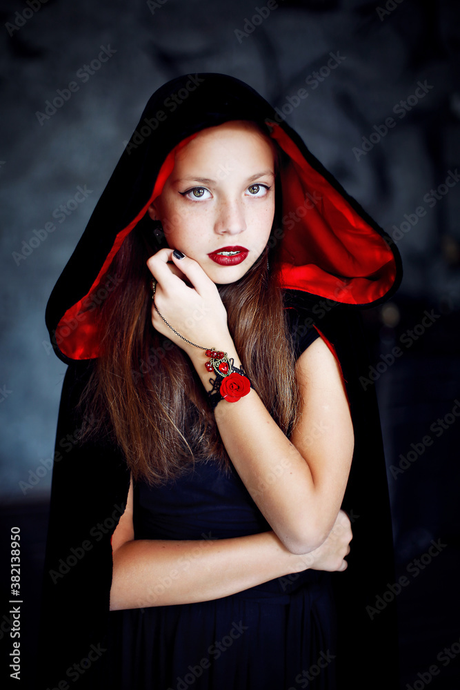 Girl in halloween style with a cape on her head
Girl in halloween style with a cape on her head