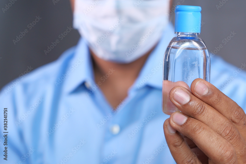 man in face mask holding sanitizer gel man in face mask holding sanitizer gel