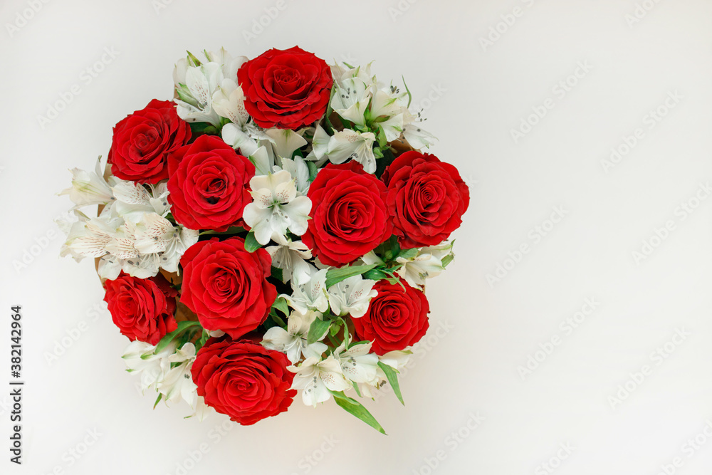 Obraz premium Bouquet with red roses and white flowers in round box. View from above.