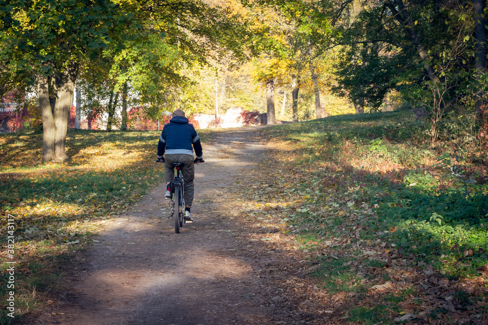 Cyclist rides a bike in the autumn city park