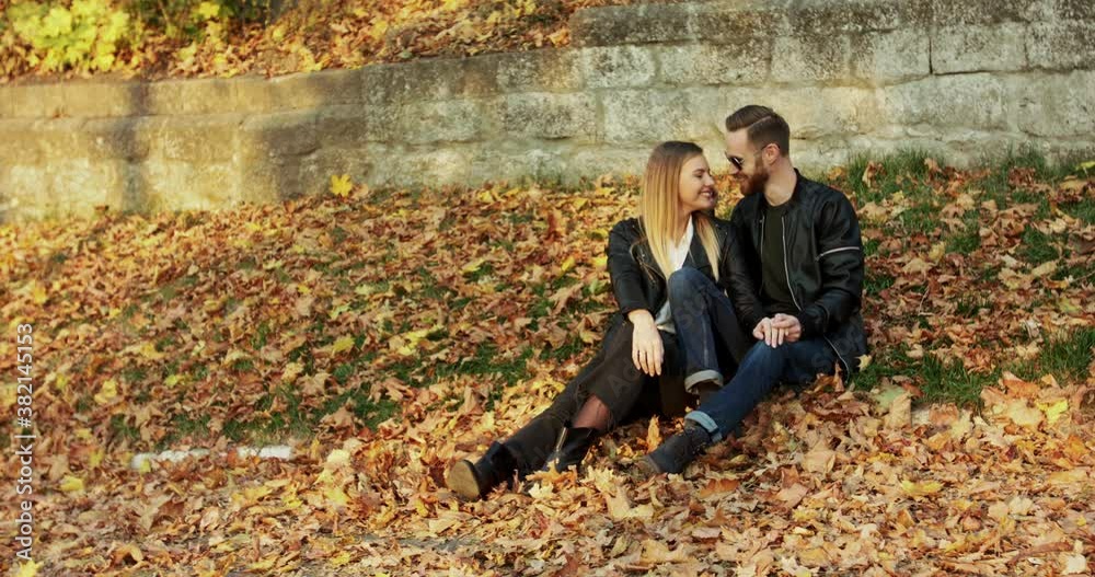 Lovely couple relaxing on autumn nature at park, they smiling and kissing Lovely couple relaxing on autumn nature at park, they smiling and kissing