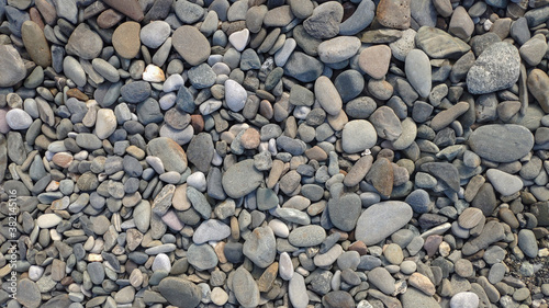 Round stones and pebbles on the beach as background, texture