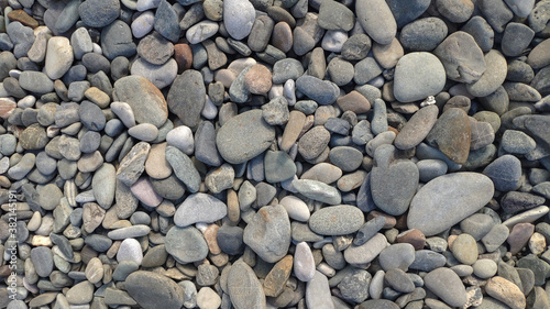 Round stones and pebbles on the beach as background, texture