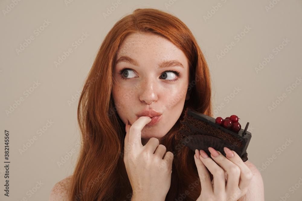 Photo of pleased redhead shirtless girl eating chocolate cake Photo of pleased redhead shirtless girl eating chocolate cake
