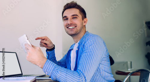 Smiling man using gadgets at home