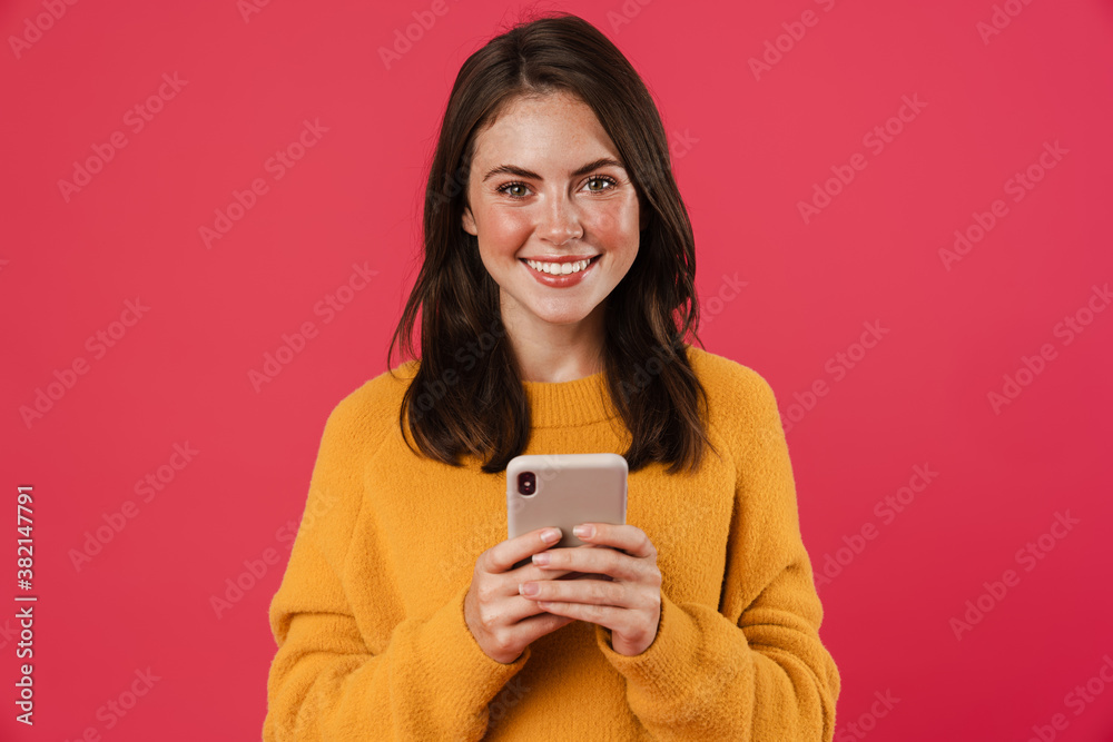 Image of joyful brunette girl smiling and using cellphone Image of joyful brunette girl smiling and using cellphone