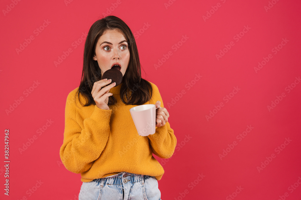 Image of surprised caucasian girl drinking coffee with cookie Image of surprised caucasian girl drinking coffee with cookie