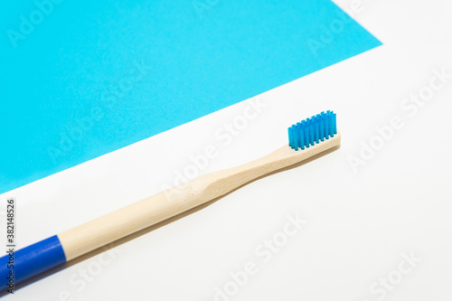 Bamboo toothbrush on a white and blue background Ecological and sustainable product concept. Eco friendly.