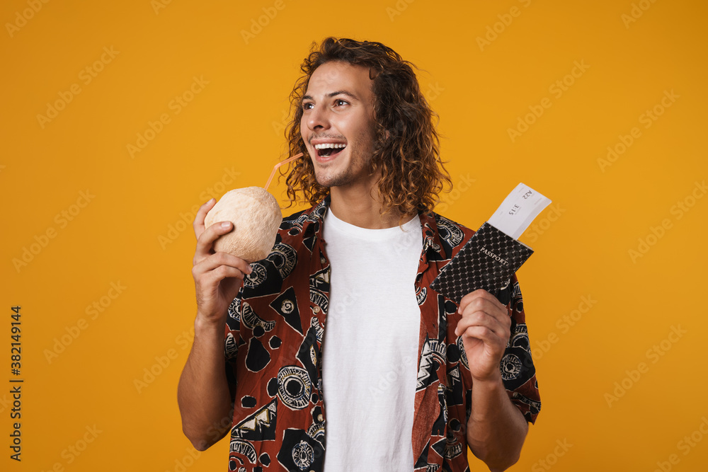 Photo of guy drinking coconut water while holding passport with tickets Photo of guy drinking coconut water while holding passport with tickets