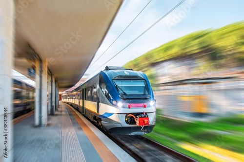 Express commuter suburban train passing through the passenger station. © aapsky