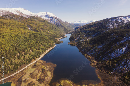 Colourful mountains valley  blue snow covered peaks  orange and green autumn forest and mountain lake. Aerial view