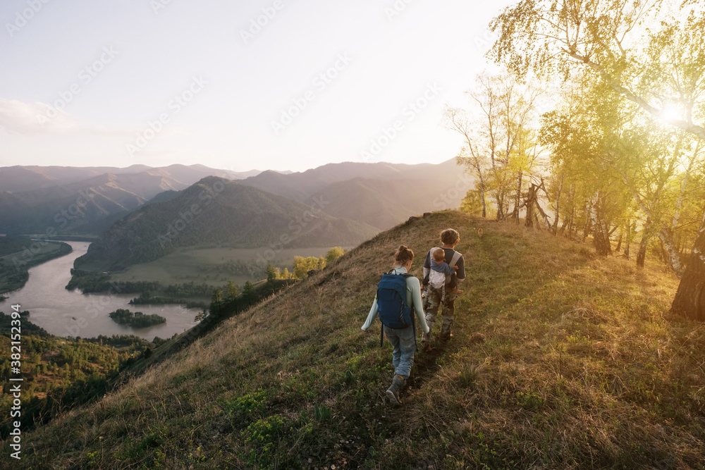 Obraz premium family with kid sitting on the neck walking in beautiful mountains