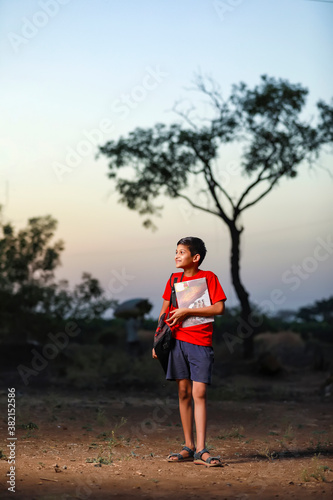 Cute little Indian / Asian school boy with note book and bag