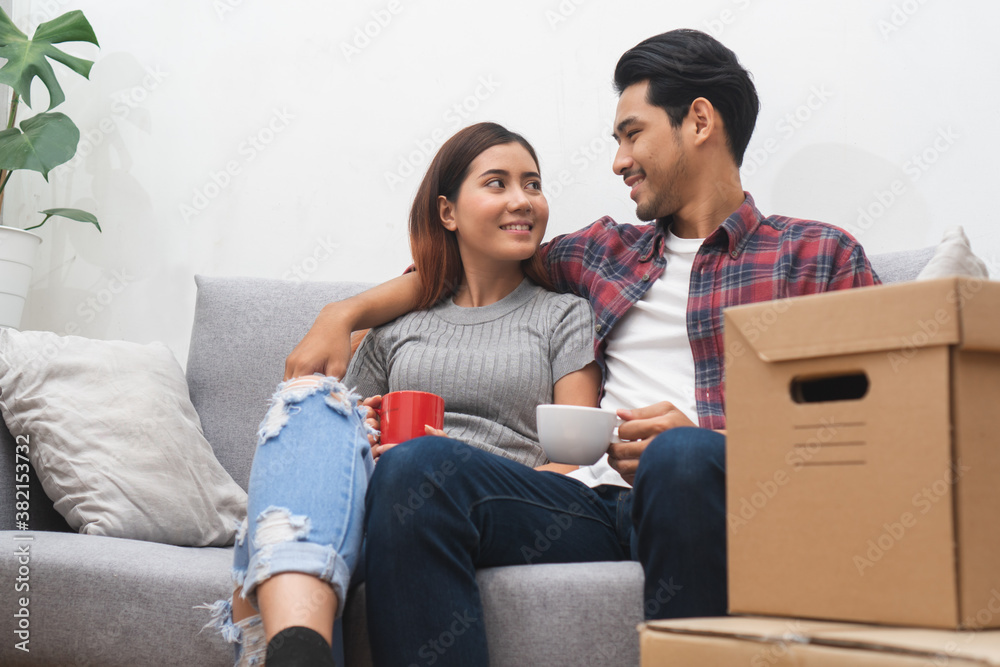 new house / home moving and relocation concept. Happy asian new married couple looking at each other face after moving in new apartment and start new life together. new house / home moving and relocation concept. Happy asian new married couple looking at each other face after moving in new apartment and start new life together.