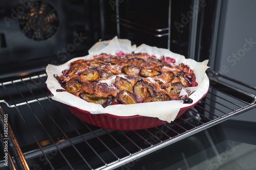 Freshly baked rustic plum cake at home in the oven in the kitchen. Homemade baking.