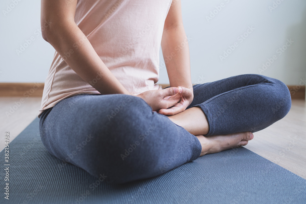 Yoga and meditation lifestyles. close up view of young beautiful woman practicing yoga namaste pose in the living room at home.